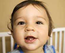 A close up photo of an infant whose teeth are starting to come in